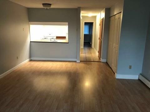 interior space featuring wood-type flooring and a baseboard heating unit