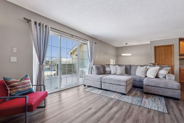 living room with wood-type flooring and a textured ceiling