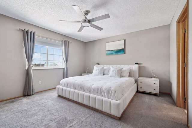 carpeted bedroom featuring ceiling fan and a textured ceiling