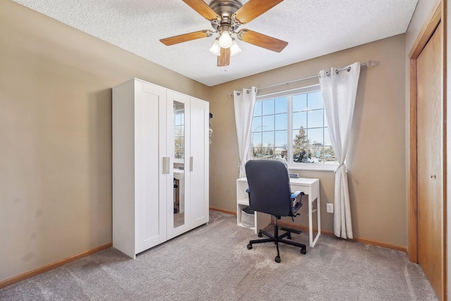 carpeted office space with a textured ceiling and ceiling fan