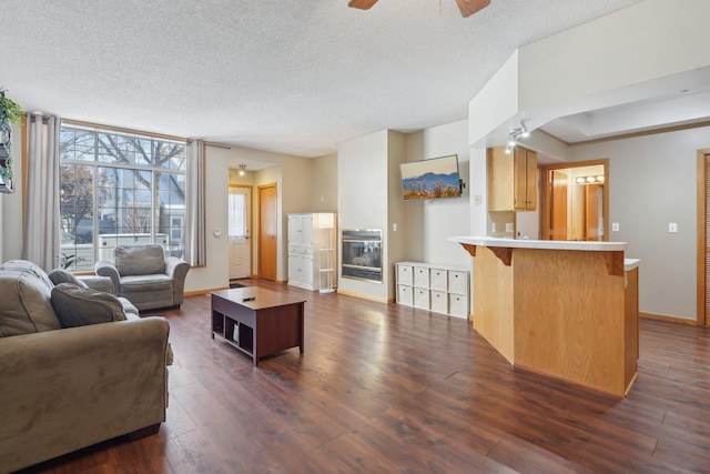 living room with dark hardwood / wood-style flooring, ceiling fan, floor to ceiling windows, and a textured ceiling