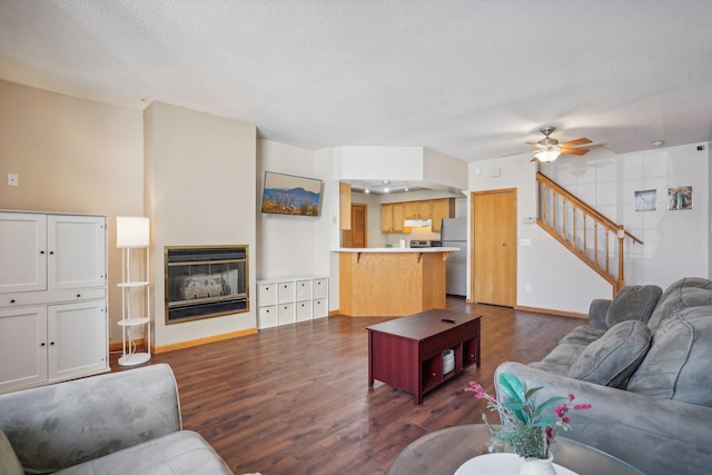 living room with ceiling fan, dark hardwood / wood-style flooring, and a textured ceiling