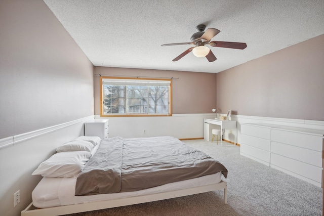 bedroom featuring a textured ceiling, ceiling fan, and carpet