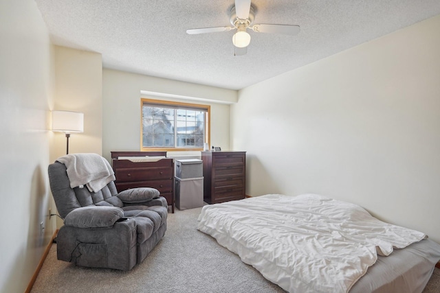 bedroom featuring a textured ceiling, light colored carpet, and ceiling fan