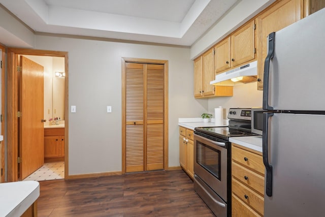 kitchen with under cabinet range hood, appliances with stainless steel finishes, light countertops, and dark wood-style flooring