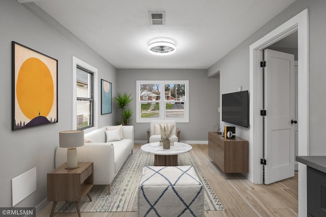 living room featuring a textured ceiling and light hardwood / wood-style flooring