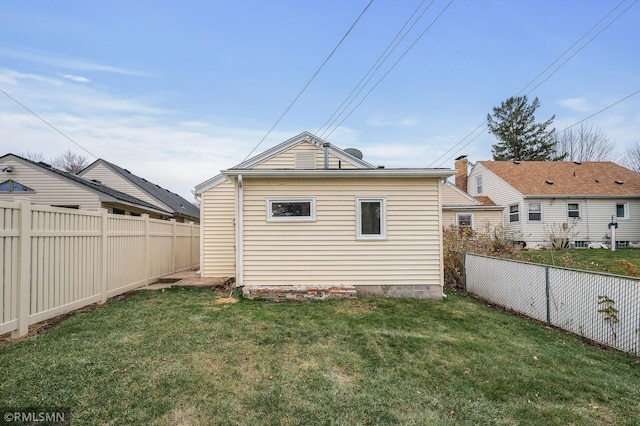 rear view of property featuring a lawn