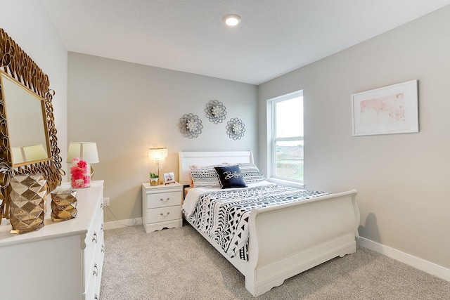 bedroom featuring light carpet and baseboards