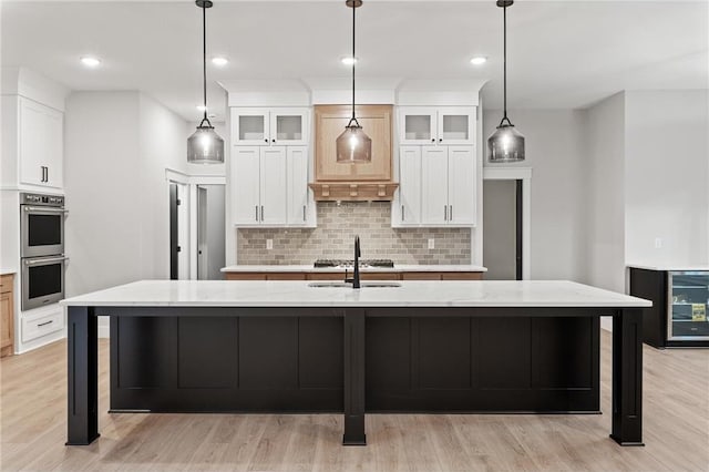 kitchen with light stone countertops, pendant lighting, and a large island