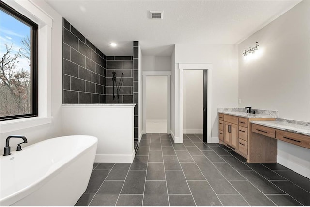 bathroom with separate shower and tub, tile patterned floors, vanity, and a textured ceiling