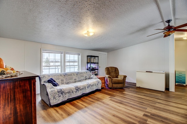 15331 129th Ave, Wadena, MN 56482 - living room featuring wood finished floors, ceiling fan, vaulted ceiling, and a textured ceiling