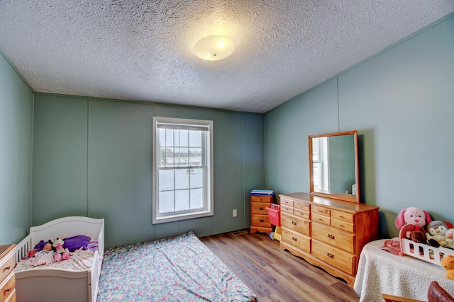 15331 129th Ave, Wadena, MN 56482 - bedroom featuring wood finished floors, a decorative wall, and a textured ceiling