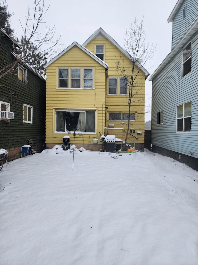 view of snow covered rear of property