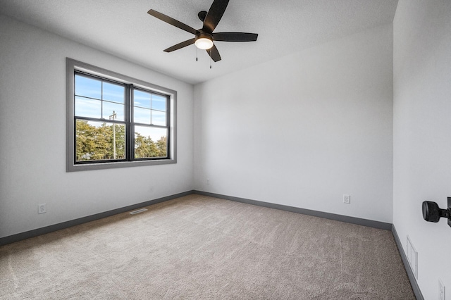 carpeted empty room with a textured ceiling and ceiling fan