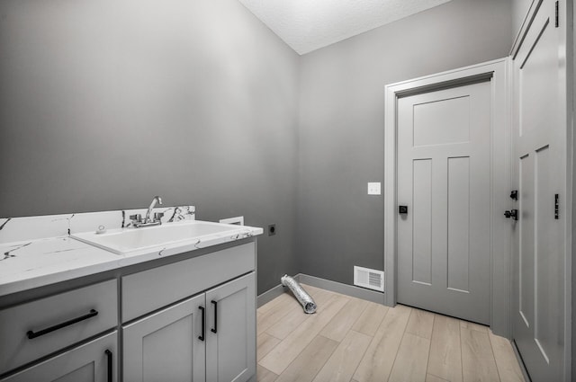 bathroom with hardwood / wood-style flooring, vanity, and a textured ceiling