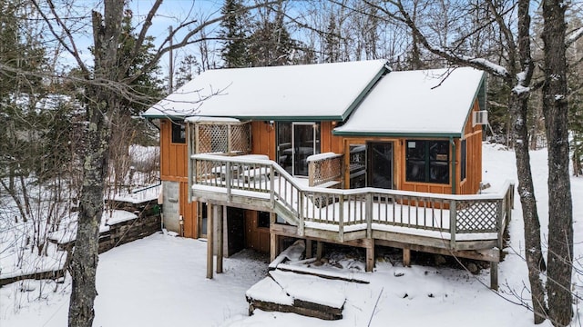 snow covered rear of property with a wooden deck