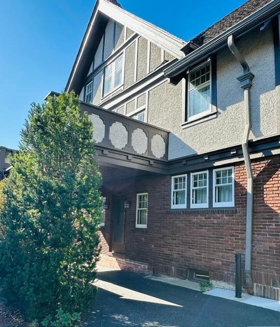 view of side of home with a balcony, brick siding, and stucco siding