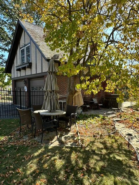 view of yard featuring a patio area, an attached garage, and fence