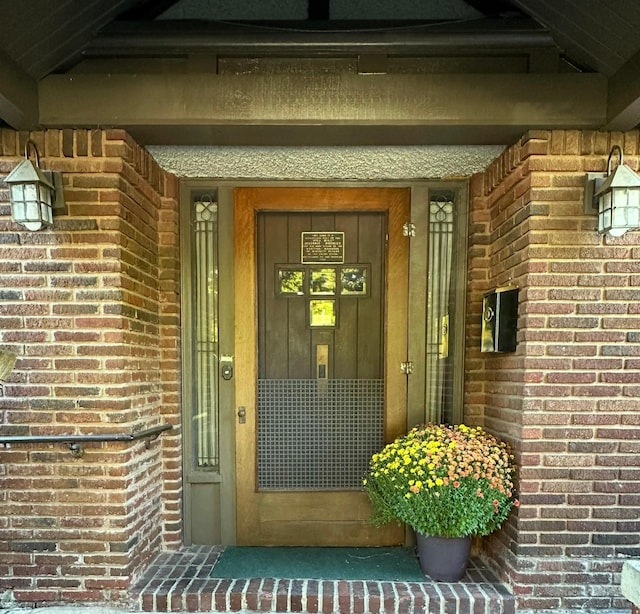 entrance to property featuring brick siding