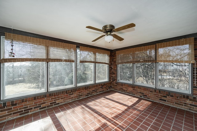 unfurnished sunroom featuring a ceiling fan