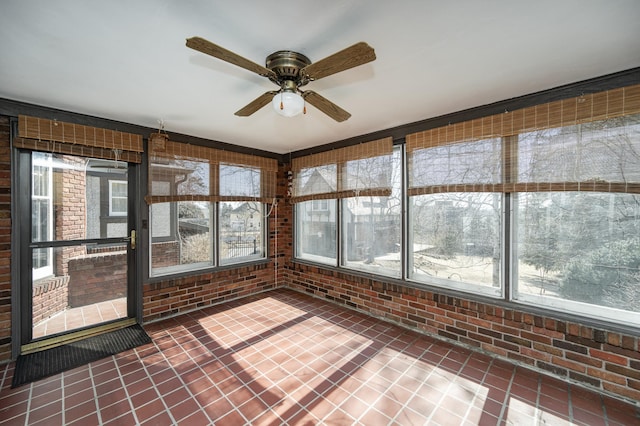 unfurnished sunroom featuring a ceiling fan