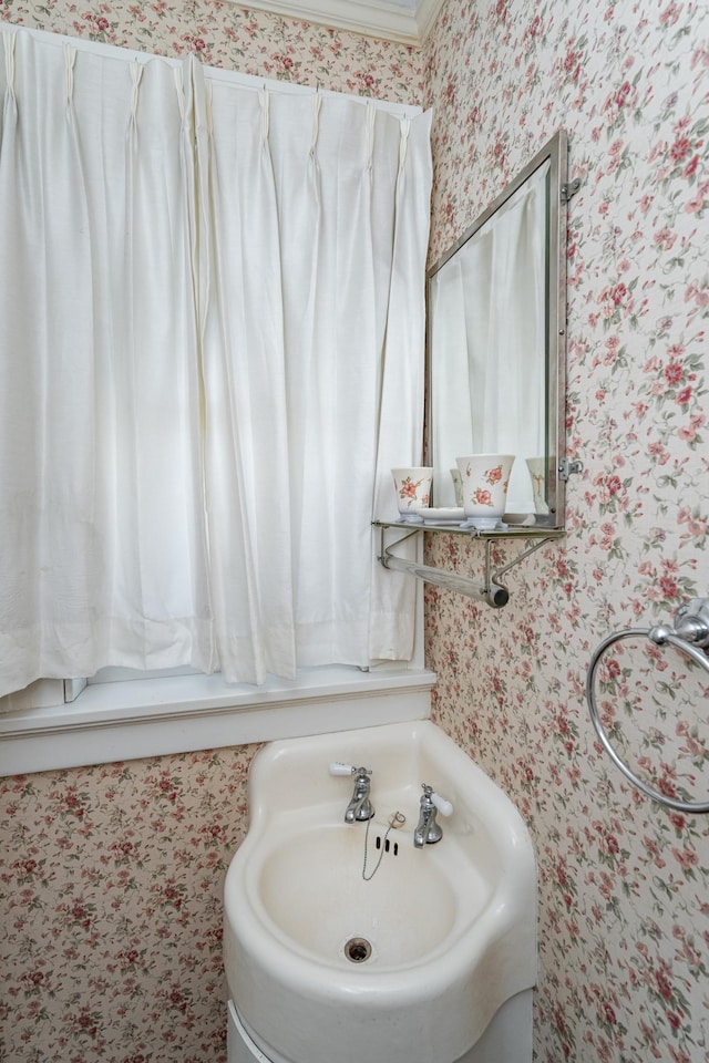 bathroom with a sink and wallpapered walls