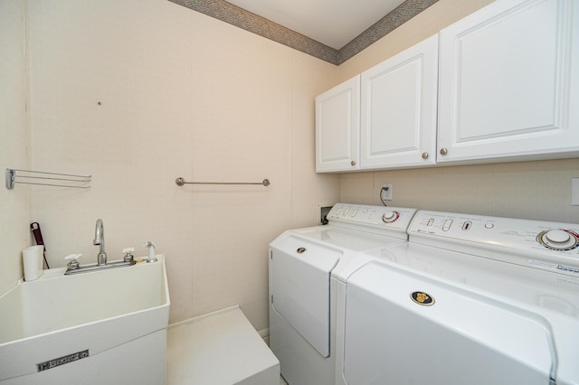 washroom featuring washer and dryer, cabinet space, and a sink