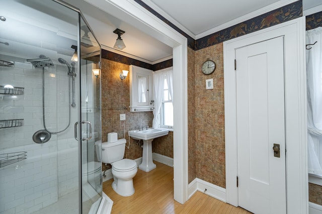 full bath with toilet, a stall shower, ornamental molding, wallpapered walls, and baseboards