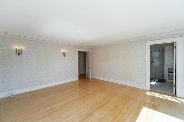 unfurnished room with baseboards, hardwood / wood-style flooring, ornamental molding, and wallpapered walls