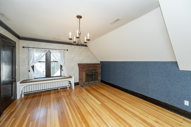 additional living space featuring wallpapered walls, hardwood / wood-style flooring, radiator heating unit, and visible vents