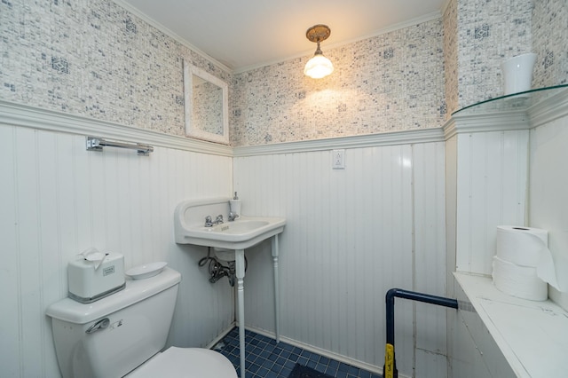 bathroom featuring tile patterned floors, a wainscoted wall, and toilet