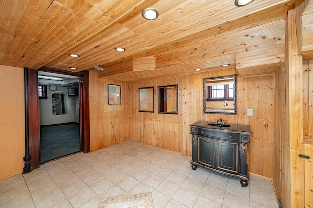 interior space featuring wooden walls, wooden ceiling, and a sink