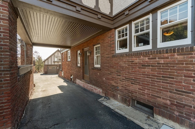 view of side of property with an outbuilding and brick siding