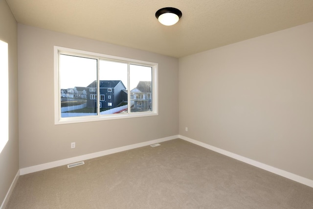 unfurnished room featuring carpet flooring and a textured ceiling