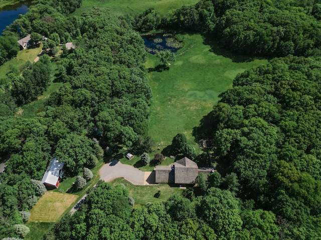 birds eye view of property featuring a wooded view and a water view