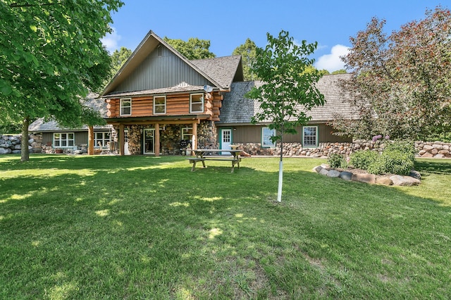 back of house featuring a yard and stone siding