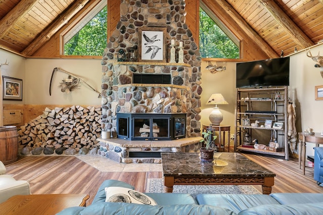 living area with a stone fireplace, wood finished floors, wood ceiling, and beam ceiling