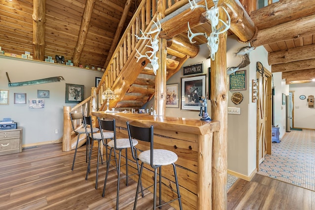 kitchen with vaulted ceiling with beams, wood ceiling, baseboards, and wood finished floors