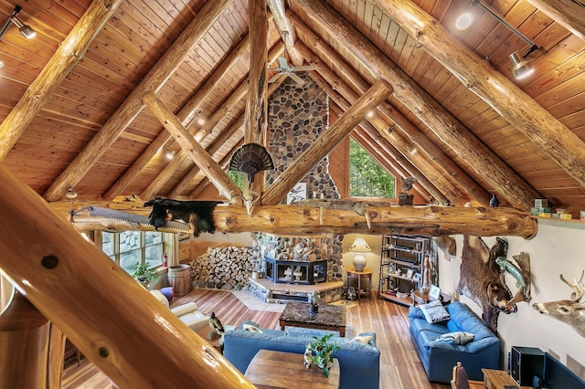 living area with beam ceiling, a healthy amount of sunlight, and hardwood / wood-style flooring