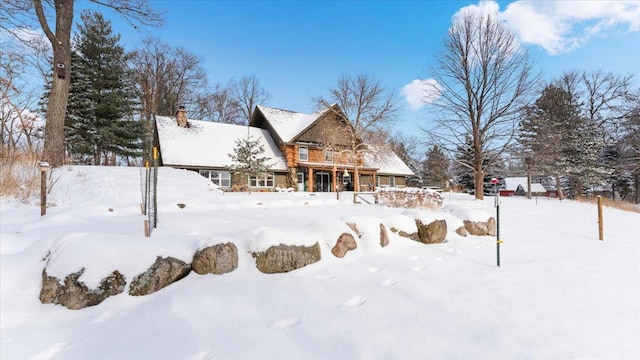 snow covered back of property with a garage