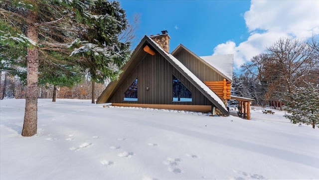 exterior space featuring log exterior and a chimney