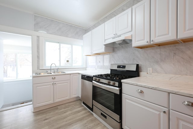 kitchen with a wealth of natural light, white cabinetry, sink, and stainless steel appliances