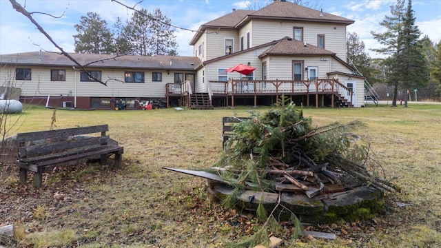 rear view of property featuring a lawn and a wooden deck