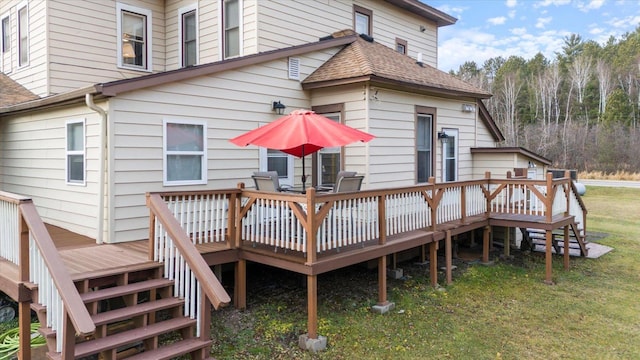 back of property featuring a wooden deck and a yard