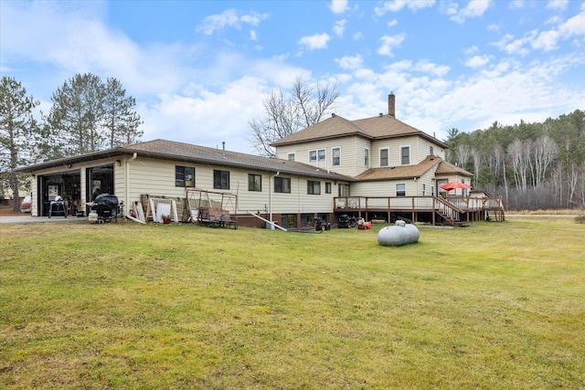 back of house featuring a deck and a lawn