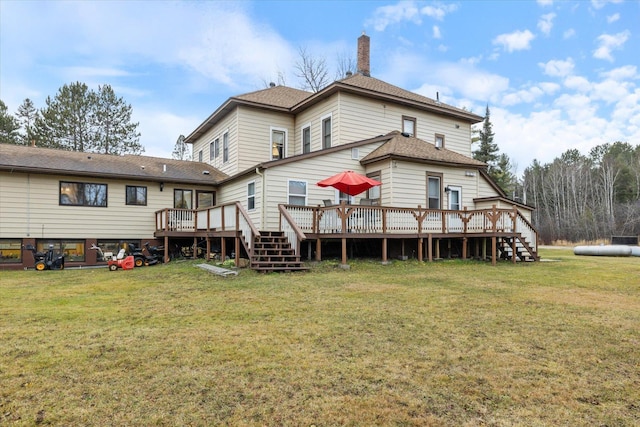 rear view of house with a deck and a lawn