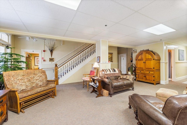 carpeted living room with a drop ceiling