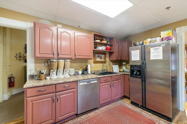 kitchen with a paneled ceiling, stainless steel appliances, and sink