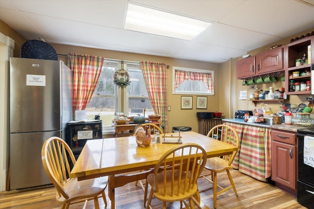 dining space with indoor bar and light wood-type flooring