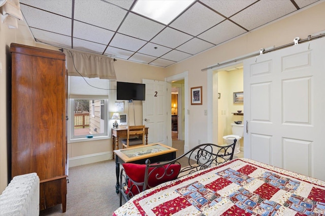 carpeted bedroom featuring a drop ceiling